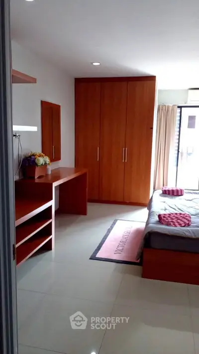 Spacious bedroom with modern wooden furniture and natural light