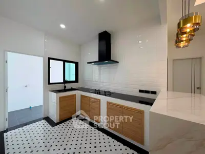 Modern kitchen with sleek design, featuring gas stove and stylish lighting, perfect for culinary enthusiasts.