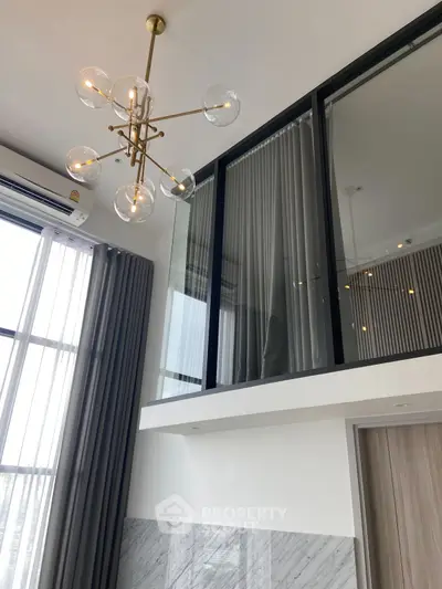 Modern duplex interior with high ceilings and elegant chandelier