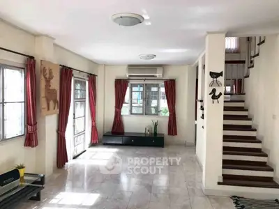 Spacious living room with natural light and modern staircase