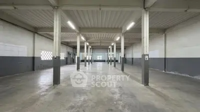 Spacious industrial warehouse with high ceilings and ample natural light, perfect for storage or manufacturing.