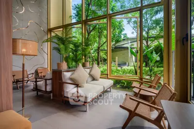 Luxurious modern living room with large windows and lush garden view, featuring elegant furniture and natural light.