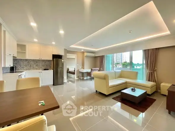 Spacious modern living room with open kitchen and elegant furnishings in a high-rise apartment.