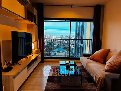 Modern living room with city view, stylish furniture, and large window for natural light.