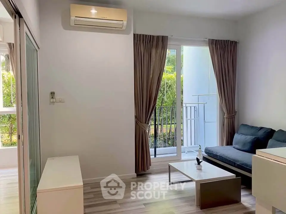 Modern living room with sleek furniture and large window overlooking greenery, perfect for relaxation.