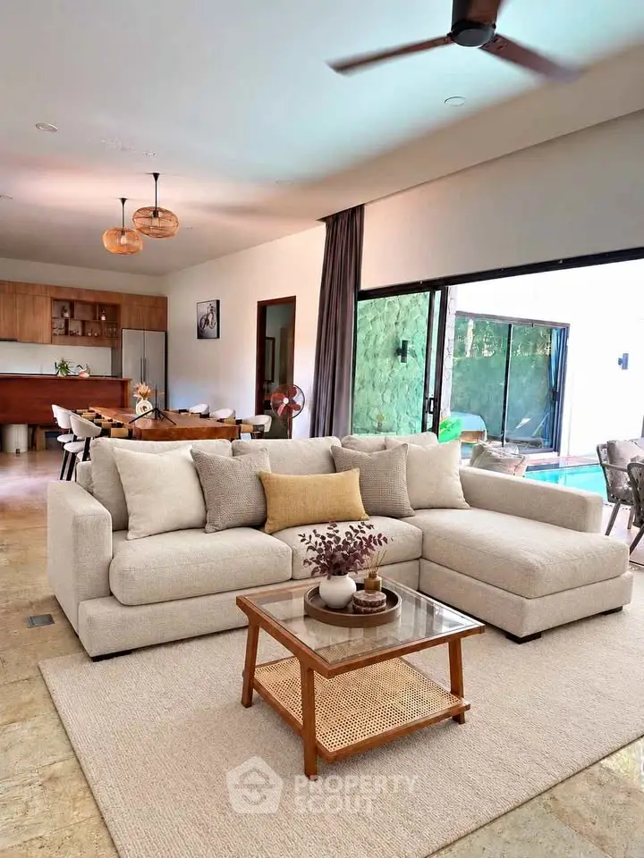 Spacious living room with modern decor and pool view, featuring a cozy sectional sofa and elegant dining area.