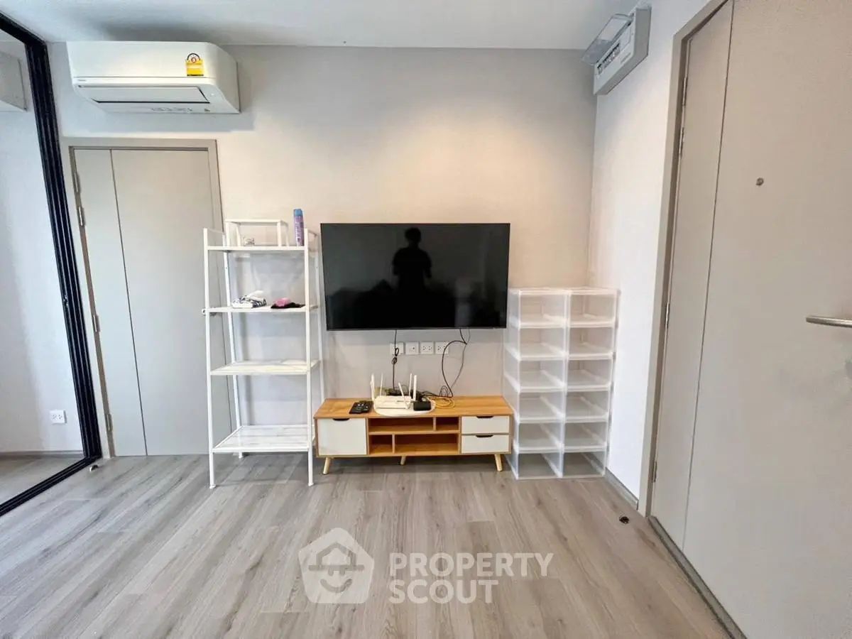 Modern living room with sleek TV setup and stylish shelving in a contemporary apartment.