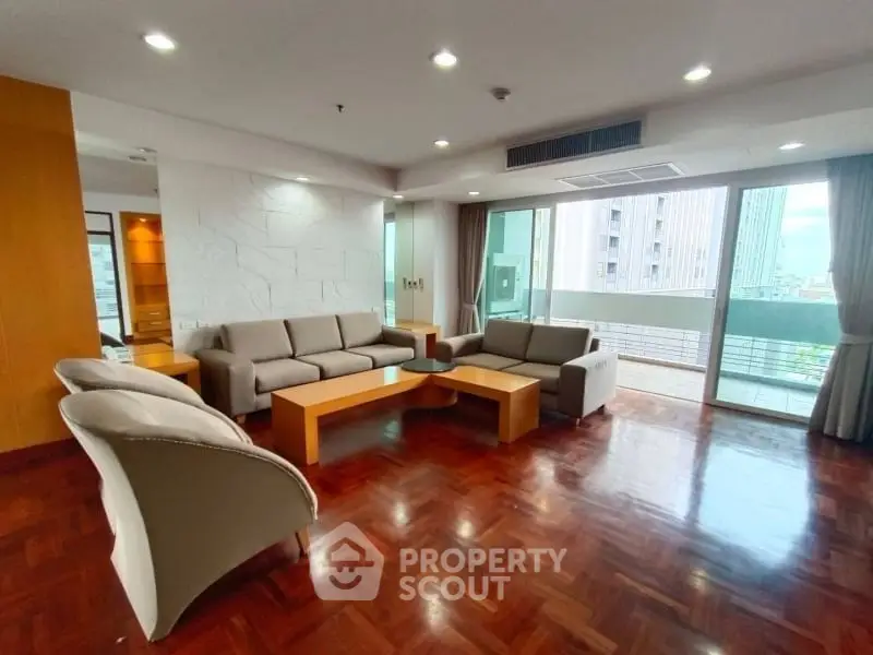 Spacious modern living room with elegant furniture and large windows offering city views.