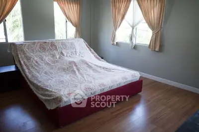 Spacious bedroom with natural light and elegant curtains