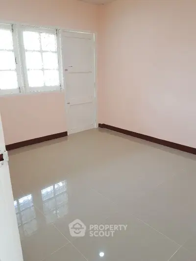 Bright empty room with tiled floor and large window, perfect for customization.