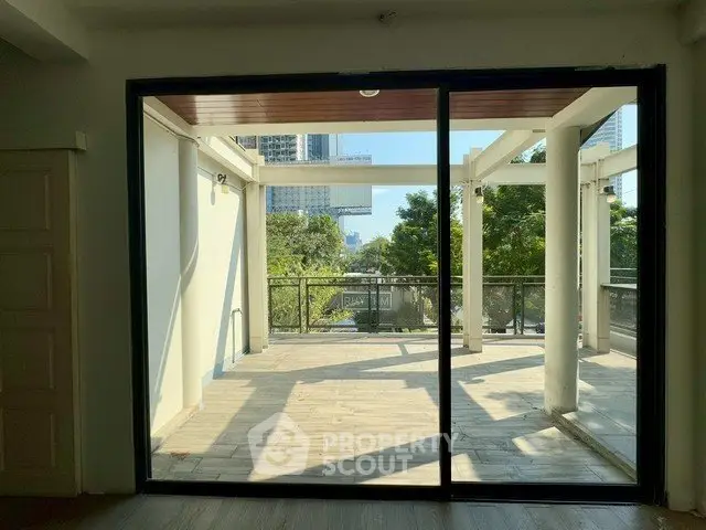 Spacious balcony with city view and modern sliding glass doors.