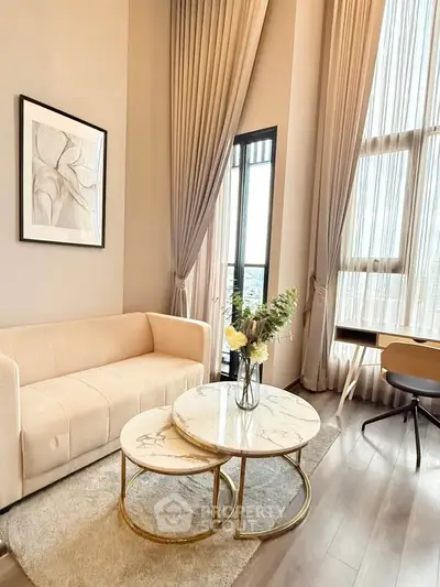 Elegant living room with high ceilings, modern furniture, and large windows offering natural light.