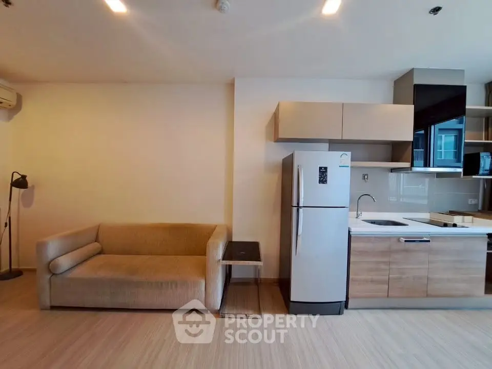 Modern open-layout living room with sleek kitchen and cozy sofa, perfect for urban living.