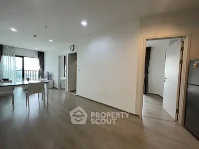 Spacious modern living room with dining area and balcony view in a stylish apartment.