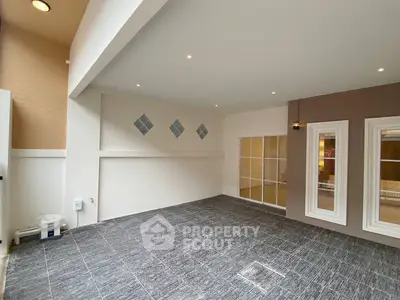 Spacious modern interior with tiled flooring and elegant lighting, perfect for versatile living space.