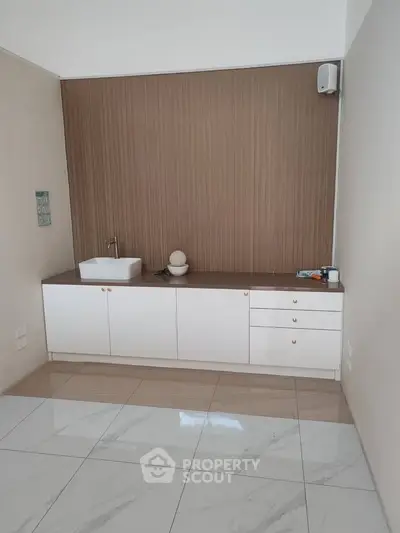 Modern minimalist kitchen with sleek cabinetry and stylish sink in a contemporary home.
