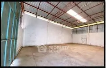 Spacious industrial warehouse with high ceilings and ample natural light.