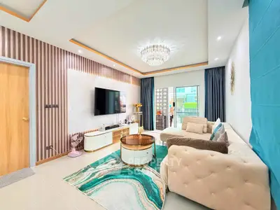 Luxurious living room with elegant decor, plush sofa, and modern chandelier, featuring a stylish TV setup and balcony view.