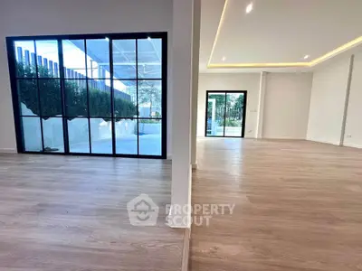 Spacious modern living room with large windows and wooden flooring