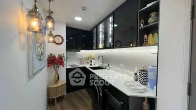 Stylish modern kitchen with sleek black cabinets and elegant lighting, featuring a compact yet functional design.