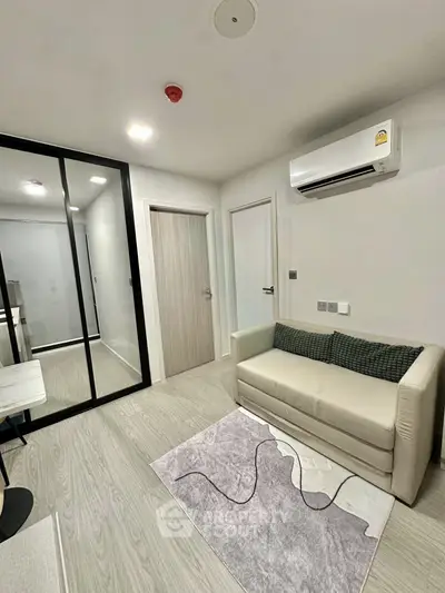 Modern living room with sleek design, featuring a cozy sofa, air conditioning, and stylish decor.