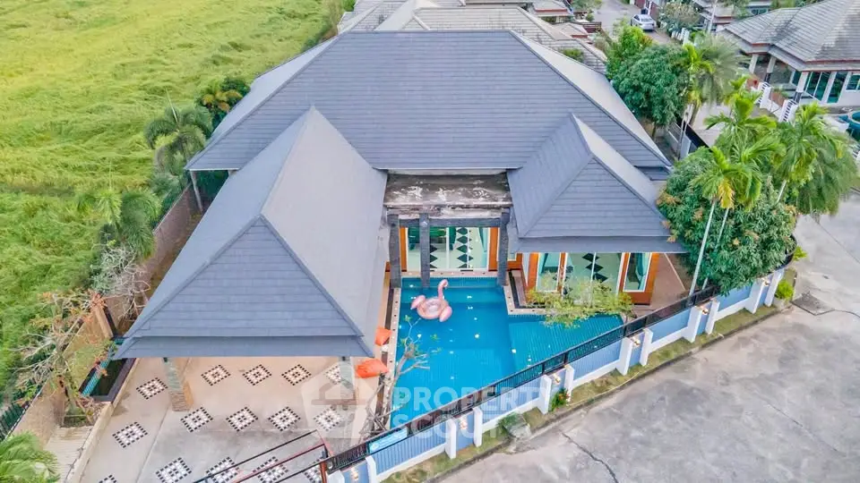 Stunning aerial view of luxury villa with private pool and lush surroundings.