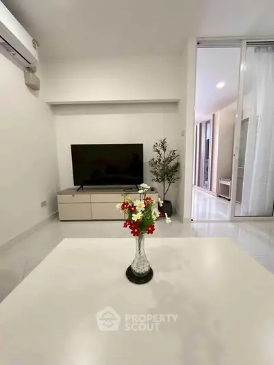 Modern living room with sleek TV setup and elegant decor in a bright apartment.