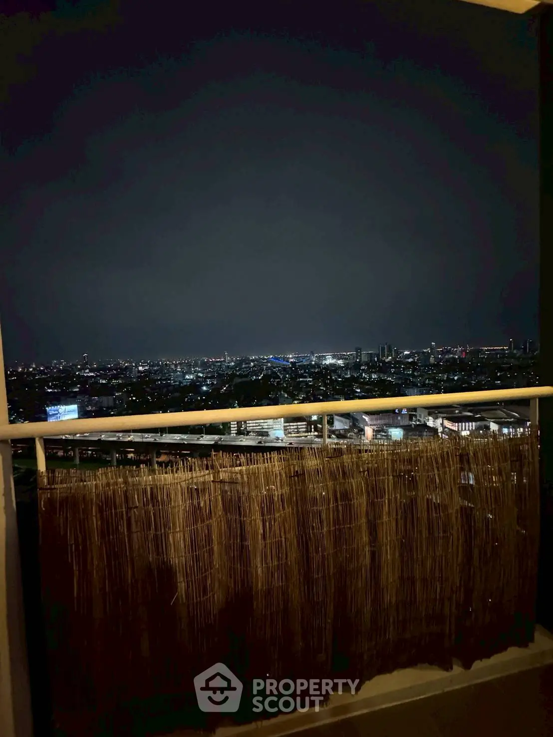 Stunning night cityscape view from a cozy balcony, perfect for urban living.