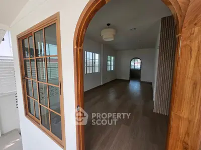 Spacious interior with wooden flooring and arched doorways, perfect for modern living.