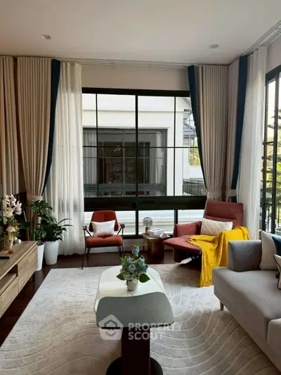 Elegant living room with large windows, modern furniture, and stylish decor