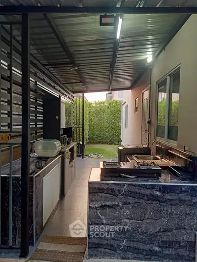 Modern outdoor kitchen with sleek marble countertops and garden view