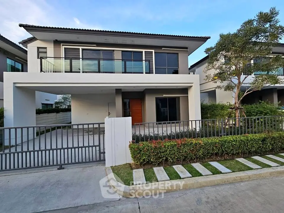 Modern two-story house with sleek design and spacious driveway in a serene neighborhood.
