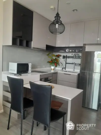 Modern kitchen with sleek cabinetry, stainless steel appliances, and stylish pendant lighting.