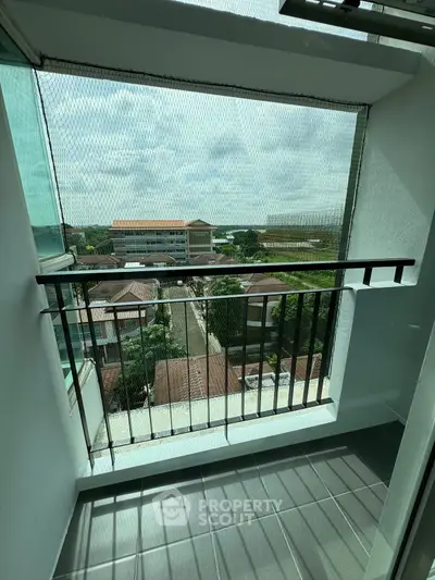 Charming balcony with safety netting and scenic view of neighborhood rooftops.