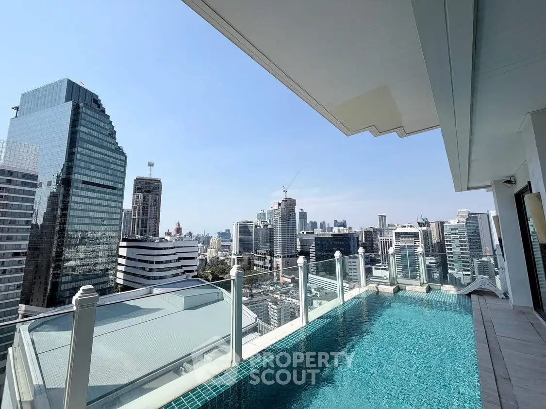 Stunning rooftop pool with panoramic city skyline view in luxury high-rise building.