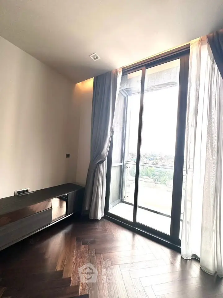 Spacious room with large window and elegant curtains offering a stunning view.