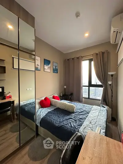 Cozy bedroom with modern decor, large window, and stylish furnishings in a high-rise apartment.