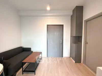 Modern living room with sleek furniture and wooden flooring in a stylish apartment.