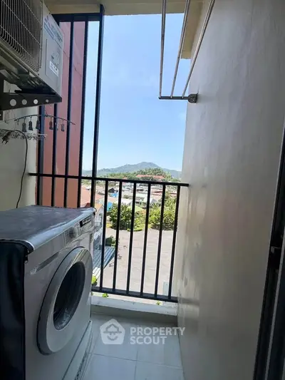 Charming balcony with washing machine and scenic mountain view, perfect for urban living convenience.