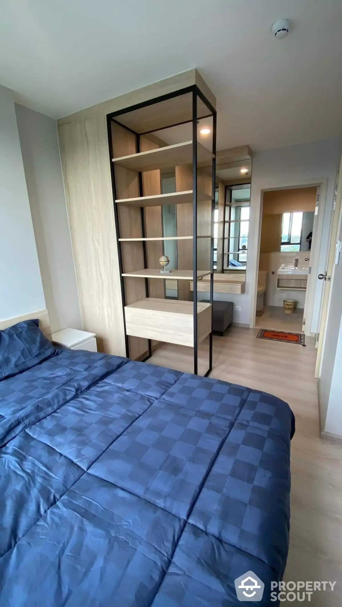 Modern bedroom with stylish shelving and cozy bedding in a contemporary apartment