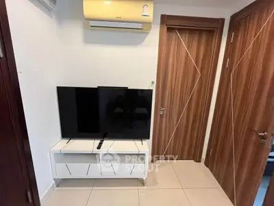 Modern living room with sleek TV setup and stylish wooden doors