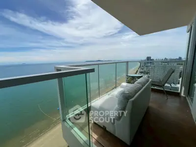 Stunning beachfront balcony with panoramic ocean views and modern seating area.