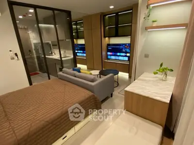 Modern studio apartment with open layout, featuring a cozy bed, sleek kitchen, and stylish living area.