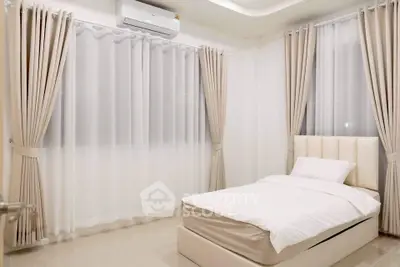 Elegant bedroom with minimalist design and soft lighting, featuring a single bed and luxurious curtains.