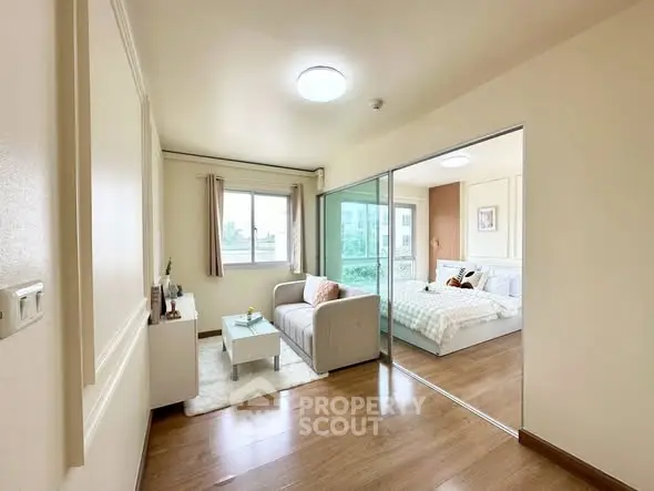 Modern apartment with cozy living room and bedroom, featuring wooden flooring and natural light.