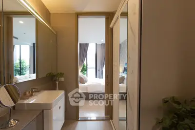 Modern bathroom with sleek design leading to a cozy bedroom with natural light.