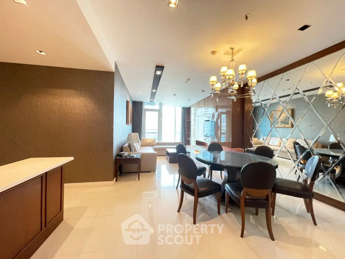 Luxurious dining area with elegant chandelier and mirrored wall in modern apartment