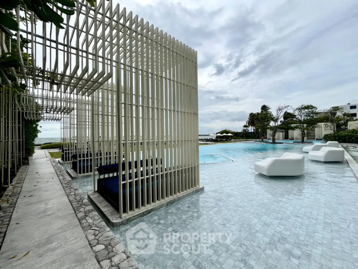 Luxurious poolside area with modern cabanas and stylish seating, perfect for relaxation and leisure.