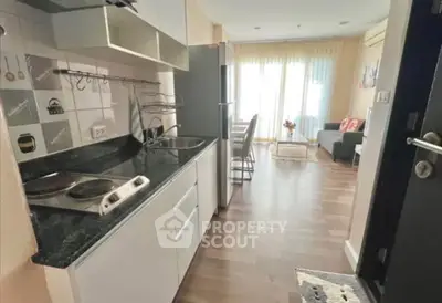 Modern open-layout kitchen with sleek appliances and cozy living area.