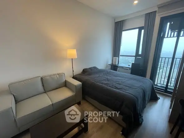 Modern bedroom with cozy sofa and balcony view